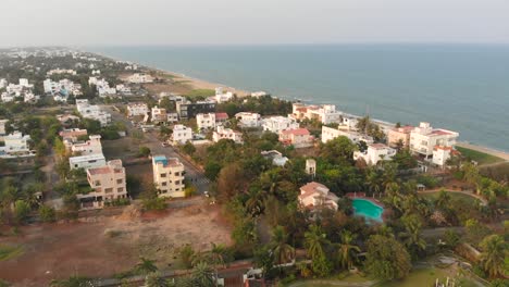 ECR-Chennai-Near-Beach-Surrounded-By-Trees,-Construction-and-Buildings-Top-View-During-Sunset