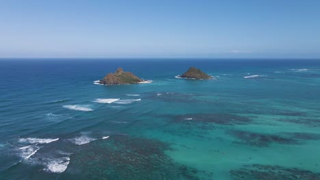 Aerial-View-Of-Mokulua-Islands,-Hawaii-with-Waves-Breaking-Over-Reef