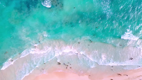 Cinematic-drone-shot-of-Playa-Del-Carmen-clear-blue-ocean-water-with-people-swimming-in-the-ocean