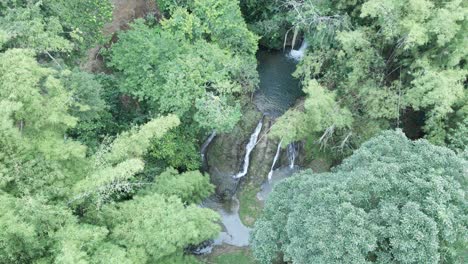 Descending-aerial-view-of-a-waterfall-deep-in-the-jungle-of-the-Caribbean-island-of-Tobago
