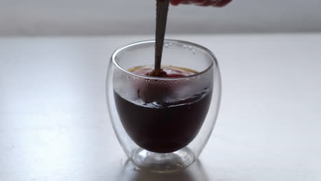 Einen-Teelöffel-Kaffeepulver-In-Ein-Doppelwandiges-Glas-Geben-Und-Umrühren,-Um-Es-Aufzulösen
