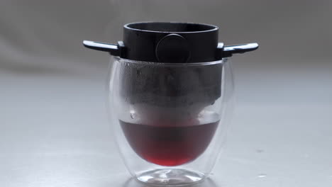 Heißer-Kaffee-Tropf-In-Doppelwandigem-Glas-Mit-Übergießfilter