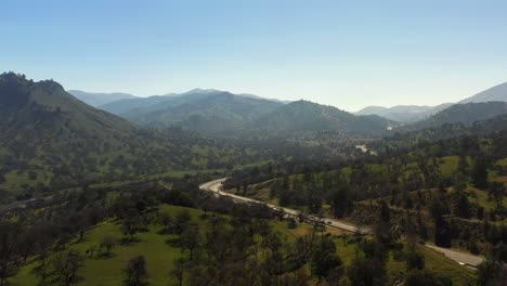 Aerial-view-of-highway-traffic-flowing-through-a-valley-in-the-Tehachapi-Mountains-during-spring