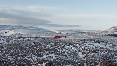 Flying-towards-stationary-helicopter-on-hill-in-winter-landscape-of-Reykjanes