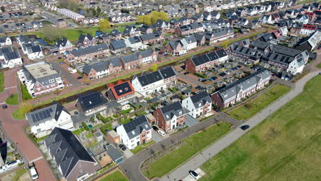 Aerial-of-car-driving-through-neighborhood-with-solar-panels-on-rooftop