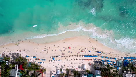 Cinematic-downward-drone-shot-lowering-towards-the-people-on-the-beach-in-Playa-Del-Carmen-Mexico