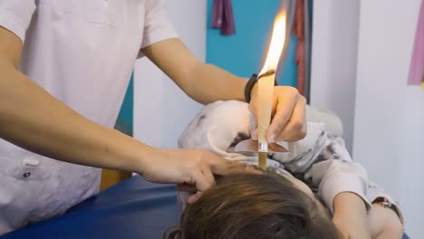 Nahaufnahme-Eines-Therapeuten,-Der-Eine-Behandlung-Zur-Entfernung-Von-Ohrenschmalz-Bei-Einem-Patienten-Mit-Kerzen-Durchführt