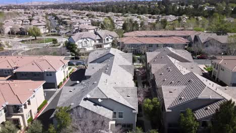 Aerial-rising,-community-of-house-in-daytime,-rooftop-homes,-Valencia,-California