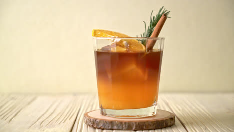 A-glass-of-iced-americano-black-coffee-and-layer-of-orange-and-lemon-juice-decorated-with-rosemary-and-cinnamon
