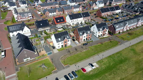 Aerial-of-houses-in-small-town-filled-with-solar-panels-on-rooftops
