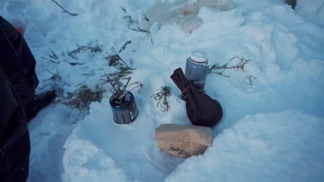 Person-Putting-Aluminum-Coffee-Maker-In-A-Portable-Cooking-Stove---Outdoor-Winter-Camping---High-Angle-Shot