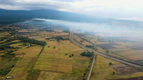 Aerial-view-of-a-wildfire-endangering-the-countryside-of-East-Africa---rising,-drone-shot