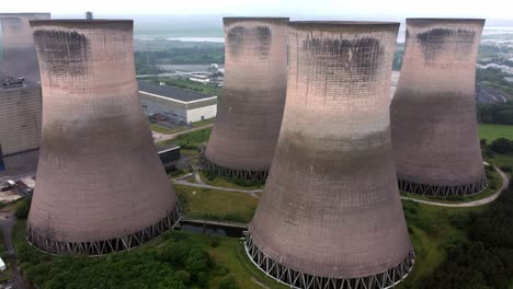 Disused-industrial-energy-power-plant-cooling-smoke-stake-chimneys-aerial-view-slow-push-between