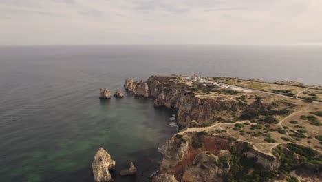Aerial-wide-of-Ponta-da-Piedade-in-Lagos-Algarve,-Portugal-under-Sunset
