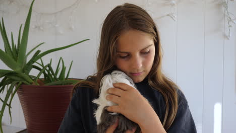 Kid-hugs-a-guinea-pig-and-strokes-its-fur-while-smiling