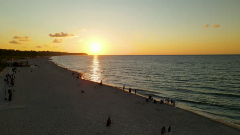 Luftaufnahme-Von-Menschen,-Die-Einen-Wunderschönen-Sonnenuntergang-Am-Strand-In-Wladyslawowo,-Polen,-Beobachten