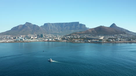 Sailboat-Traveling-Towards-The-Seaport-Of-Cape-Town-With-A-View-Of-The-Signal-Hill-And-Table-Mountain-In-South-Africa