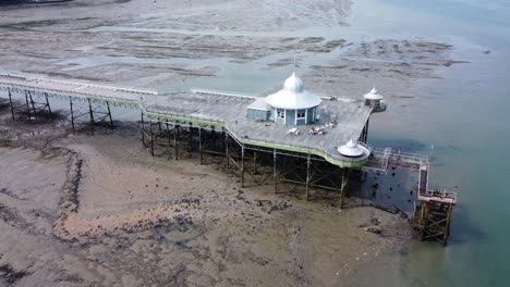 Bangor-seaside-pier-North-Wales-silver-spire-pavilion-low-tide-aerial-view-side-to-front-orbit
