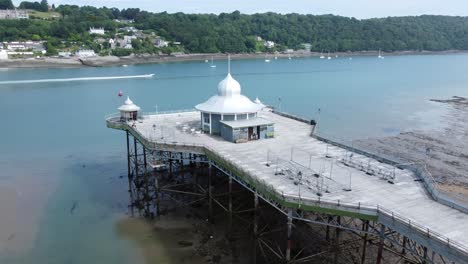 Bangor-seaside-pier-North-Wales-silver-spire-pavilion-low-tide-aerial-view-low-right-dolly-above-platform