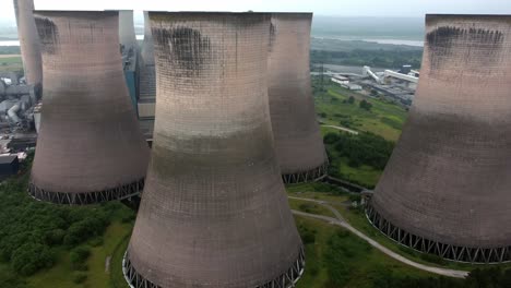 Disused-industrial-energy-power-plant-cooling-smoke-stake-chimneys-aerial-view-slow-left-orbit