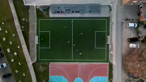 Drone-flight-from-bird's-eye-view-over-a-small-soccer-field-where-a-game-is-being-played
