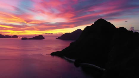 Luftaufnahme-Der-Dramatischen-Karstlandschaft-Und-Des-Türkisfarbenen-Ozeanwassers-Während-Des-Erstaunlichen-Roten-Sonnenuntergangs-In-El-Nido,-Palawan,-Philippinen