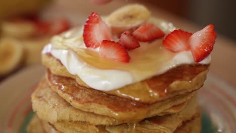 Pile-of-Crepes-Covered-in-Honey-with-Fresh-Strawberries-and-Bananas-on-Top