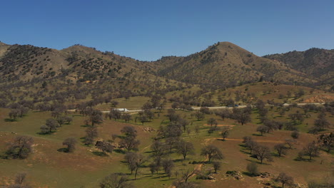 A-highway-runs-through-the-picturesque-Tehachapi-mountains-in-spring---aerial-view