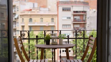 Empty-beautiful-exterior-balcony-table-with-no-people-Mediterranean-city-background-during-sunny-summer-day-wide-shot