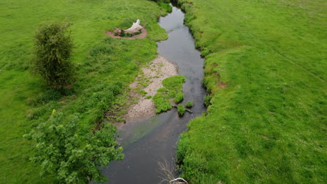 Eine-Luftaufnahme-Des-Kleinen-Flusspfeils,-Der-Durch-Die-Grünen-Felder-Von-Warwickshire,-England-Läuft