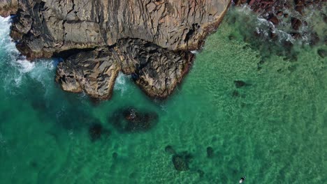 Top-View-Of-Rocky-Cliff-Of-Norries-Headland-And-Clear-Water-At-Norries-Cove-In-NSW,-Australia