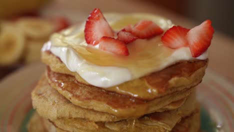 Fresh-Strawberries-Fall-on-Top-of-Stack-of-Homemade-Pancakes,-Slow-Motion-Close-Up