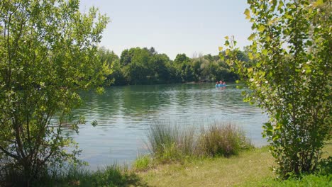 Schöne-Landschaft-Eines-Sees,-Umgeben-Von-Grünem-Wald-An-Einem-Sonnigen-Tag