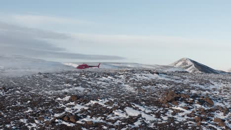 Helicopter-lands-on-snowy-hill-in-remote-arctic-landscape-at-Fagradalsfjall