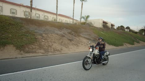 Young-woman-on-a-vintage-motorcycle-speeds-up-on-the-road-to-pass