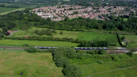 Imágenes-De-Drones-De-4k-Rastreando-Un-Tren-Azul-Que-Viaja-Hacia-Canterbury