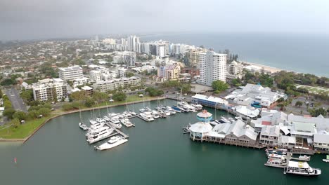 Aerial-View-Of-Luxury-Yachts-And-Boats-Moored-On-Jetty-By-Mooloolaba-River-With-Seafood-Restaurant-And-Beachfront-Hotels-In-QLD,-Australia