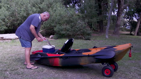 A-fisherman-removing-his-catch-from-an-ice-box-on-the-kayak-and-proceeds-to-clean-the-fish