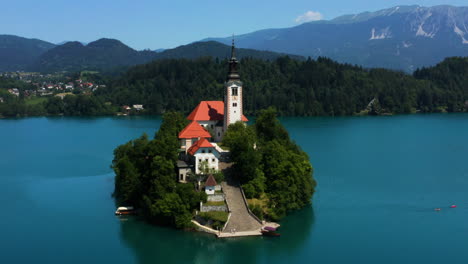 Aerial-View-Of-Bled-Island-With-Cafe,-Provost-House-And-Pilgrimage-Church-of-the-Assumption-of-Maria-By-The-Lake-in-Bled,-Slovenia
