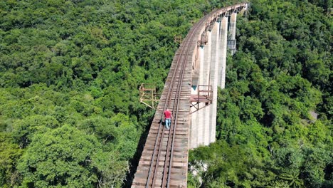 Lone-hiker-crossing-a-huge-railroad-track-across-a-valley