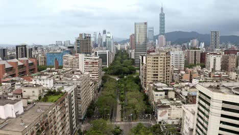 Luftflug-über-Die-Green-Renai-Avenue-In-Taipei-City-Mit-Dem-Berühmten-Hochhaus-101-Tower-Im-Hintergrund,-Taiwan