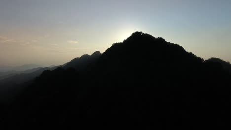 Luftaufnahme-Der-Dunklen-Bergsilhouette-Und-Der-Goldenen-Sonnenuntergangsbeleuchtung-Im-Hintergrund