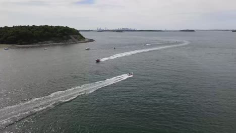 Static-drone-of-two-boats-speeding-toward-each-other-through-Hull-Gut-with-BOSTON-SKYLINE-in-the-distance