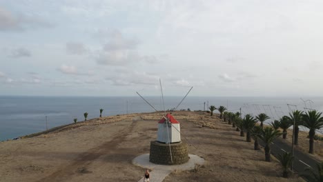 Scenic-hill-at-Porto-Santo-view-of-ocean-and-famous-Windmills,-aerial