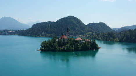 Iglesia-De-María-La-Reina-Rodeada-De-Bosque-Verde-En-La-Isla-En-El-Lago-Bled,-Eslovenia