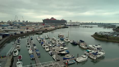 Boats-Moored-In-Jetty-With-Virgin-Voyages-Scarlet-Lady-Cruise-Ship-Docked-At-Terminal-Of-Portsmouth-In-England,-United-Kingdom