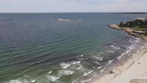 Aerial-footage-from-a-drone-descending-over-the-Sandy-Beach-Cohasset,-MA-USA