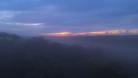 Aerial:-Flying-low-over-fog-and-forest-during-a-glowing-morning-sunrise-in-Australia