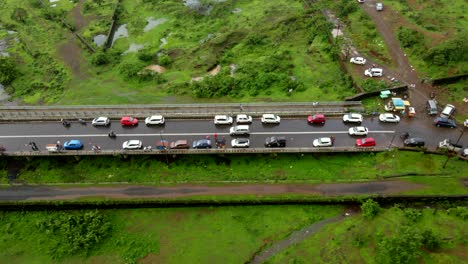 lonavla-city-hill-station-dron-shot-following-car-top-view-birds-eye-view-in-rainy-day-city-inova-passing-thrugh-traffic-off-road-Bhushi-Dam-city-