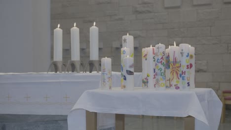 Auf-Einem-Altar-Stehen-Bunte-Kerzen,-Die-Flammen-Flackern